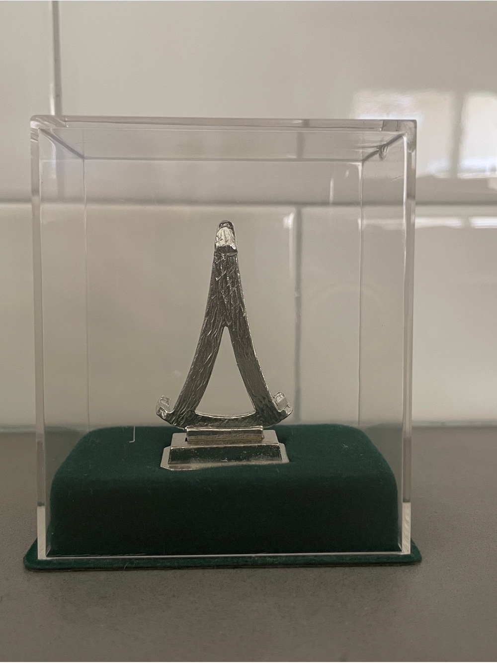 A miniature Eiffel Tower souvenir replica in a display case.